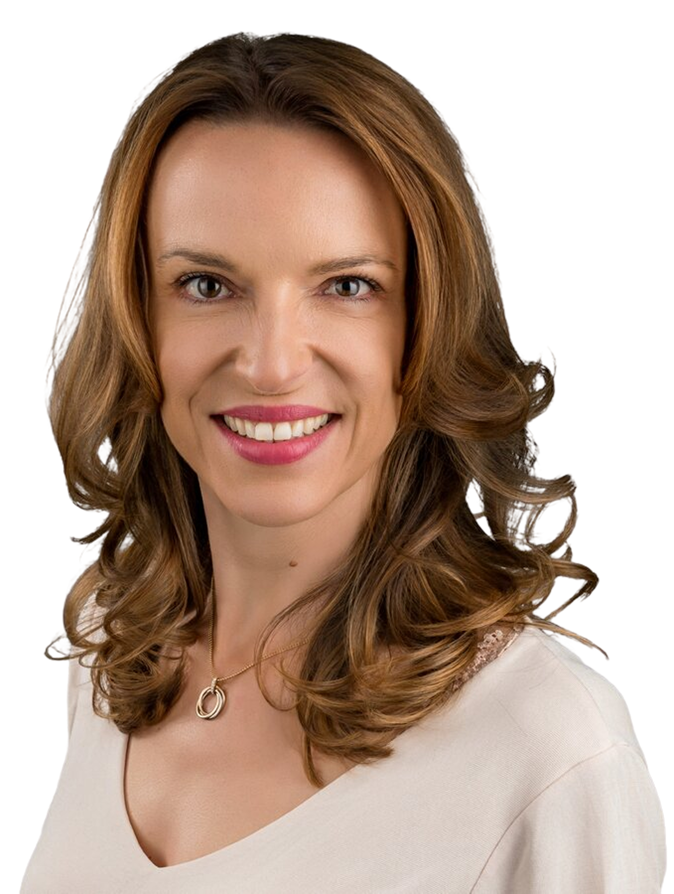Frau mit langen braunen gewellten Haaren, die ein helles Oberteil und eine Halskette trägt, lächelt in die Kamera vor einem schlichten weißen Hintergrund.