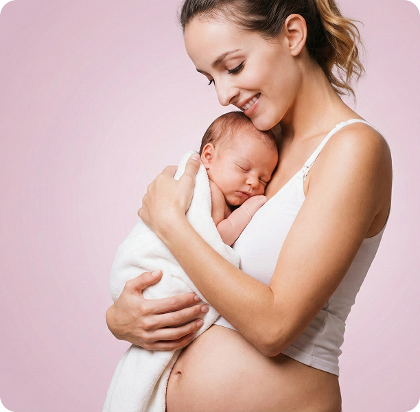 Eine Frau mit sichtbarem Babybauch hält ein in eine weiße Decke eingewickeltes Neugeborenes, beide vor einem rosa Hintergrund.