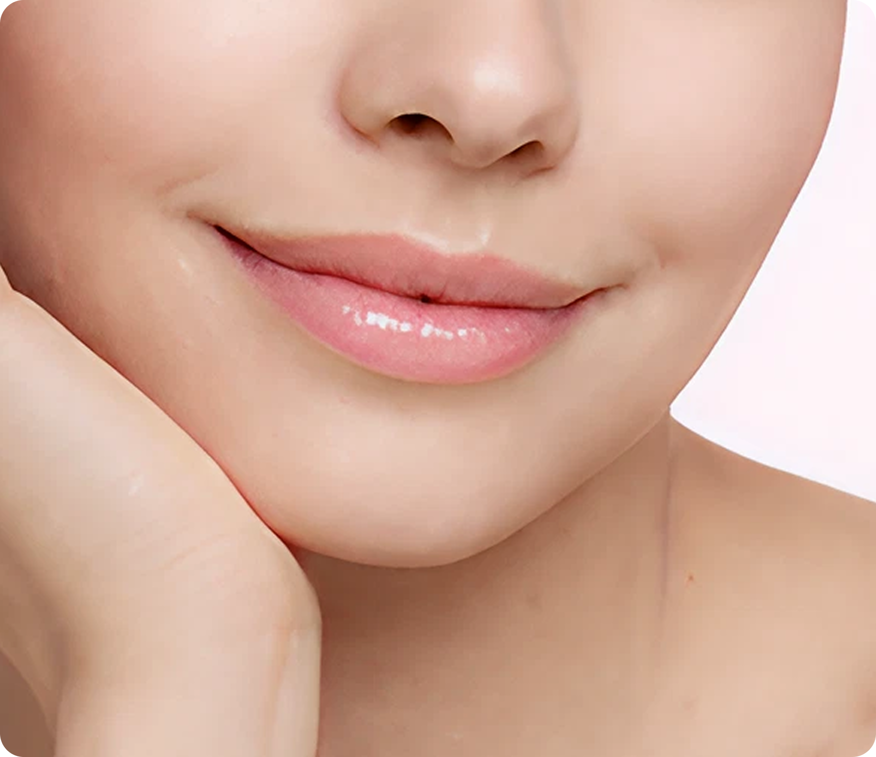 Nahaufnahme einer Person mit klarer, glatter Haut, die ihr Gesicht berührt und leicht lächelnde, natürlich geschminkte Lippen zeigt.