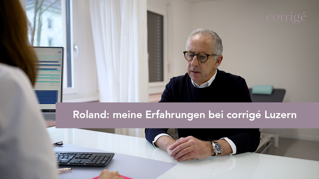 Ein älterer Mann sitzt an einem Schreibtisch in einer Arztpraxis und spricht mit einer medizinischen Fachkraft. Der Text ist eingeblendet: "Roland: meine Erfahrungen bei corrigé Luzern.